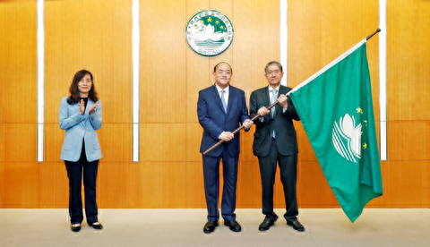 图为贺一诚将特区区旗授予马有恒.(澳门体育局供图)