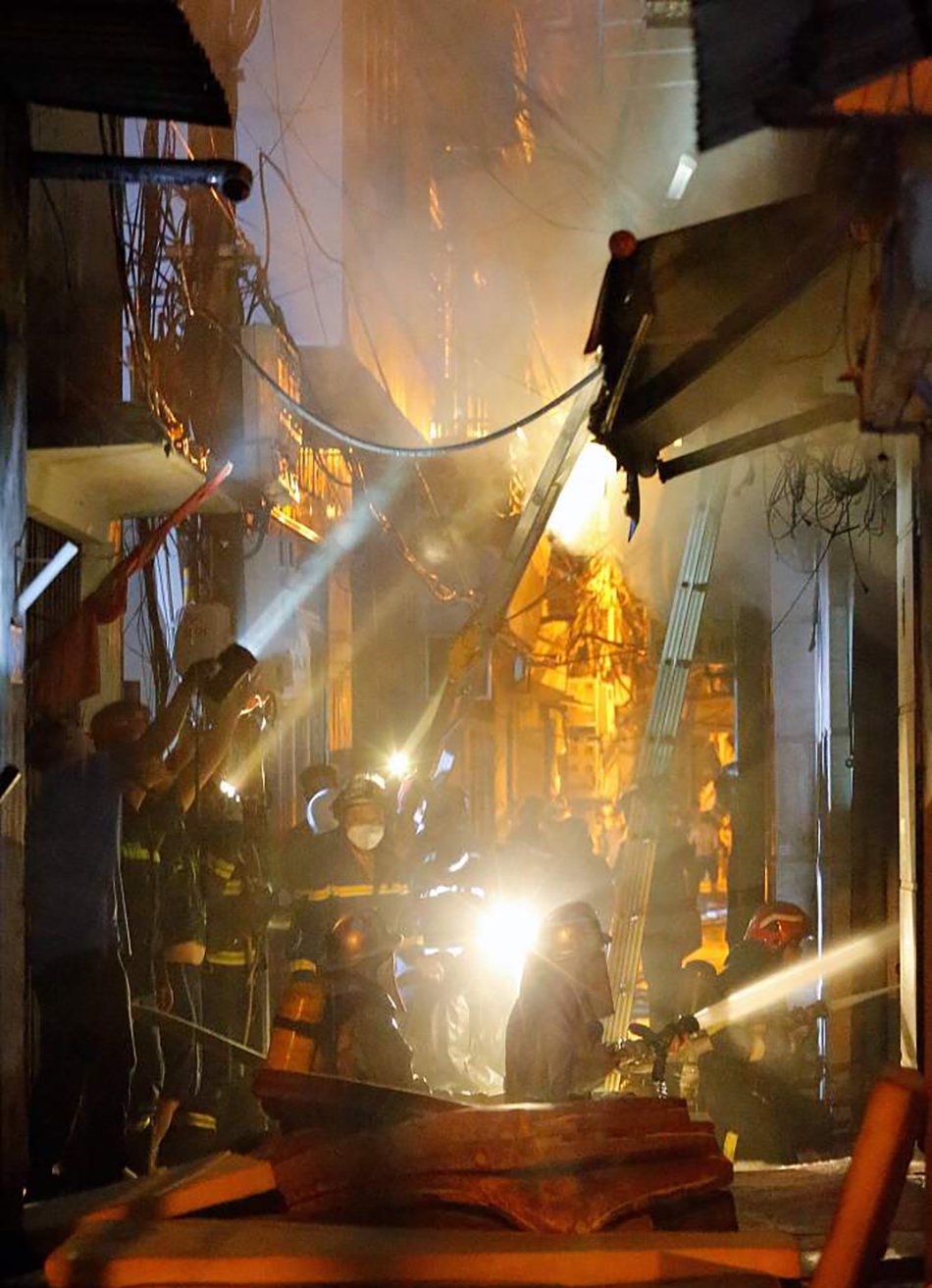 当地时间2023年9月13日,越南河内,一栋民宅发生大火,消防队员正在灭火