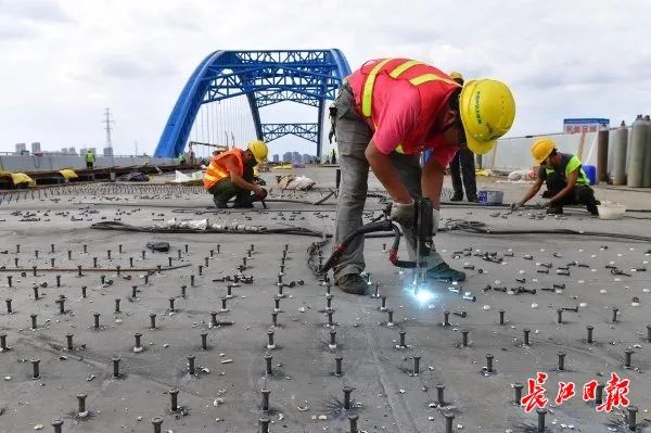 工程已进入主桥桥面铺装阶段，施工人员正在桥面焊接剪力钉。 记者李永刚 摄
