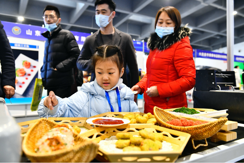2月24日，2023中国（日照）海洋食品预制菜发展大会在山东日照举行。图为市民在品尝预制菜。新华社记者 郭绪雷 摄