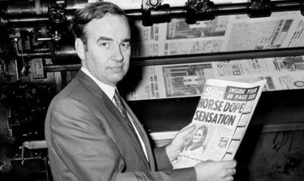 1969年11月，默多克翻看自己收购后的首版《太阳报》（图源：PA）