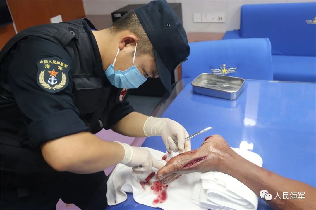中国海军阿坝舰军医正在为菲律宾受伤渔民处理伤口 潘跃强 摄