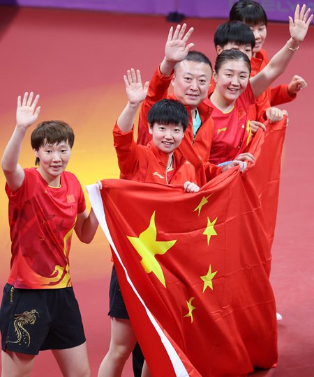 图为中国女队主教练马琳与队员们举起国旗庆祝胜利.刘占崑/摄