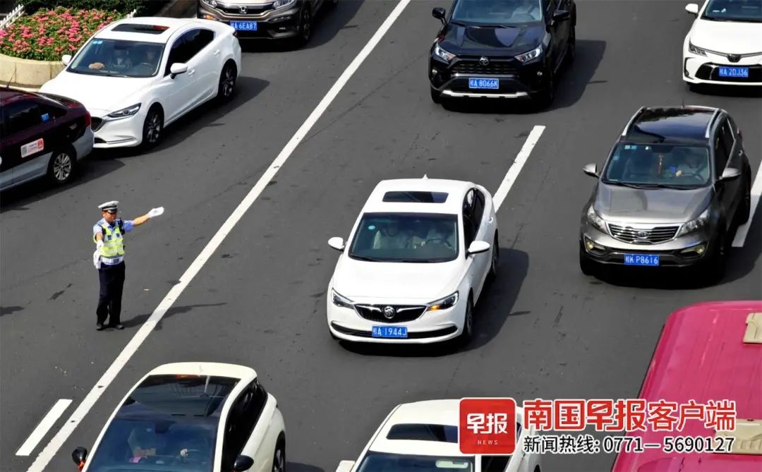 9月29日上午,南宁各大主干道车流量大,交警在疏导车辆通行.