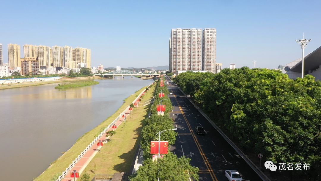化州市整洁规划的城市主干道,葱郁丰茂的绿道,在五星红旗的点缀下相