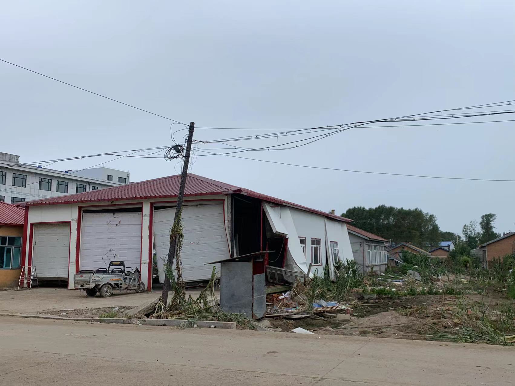 向阳镇街上,被水冲歪的车库.高佳摄