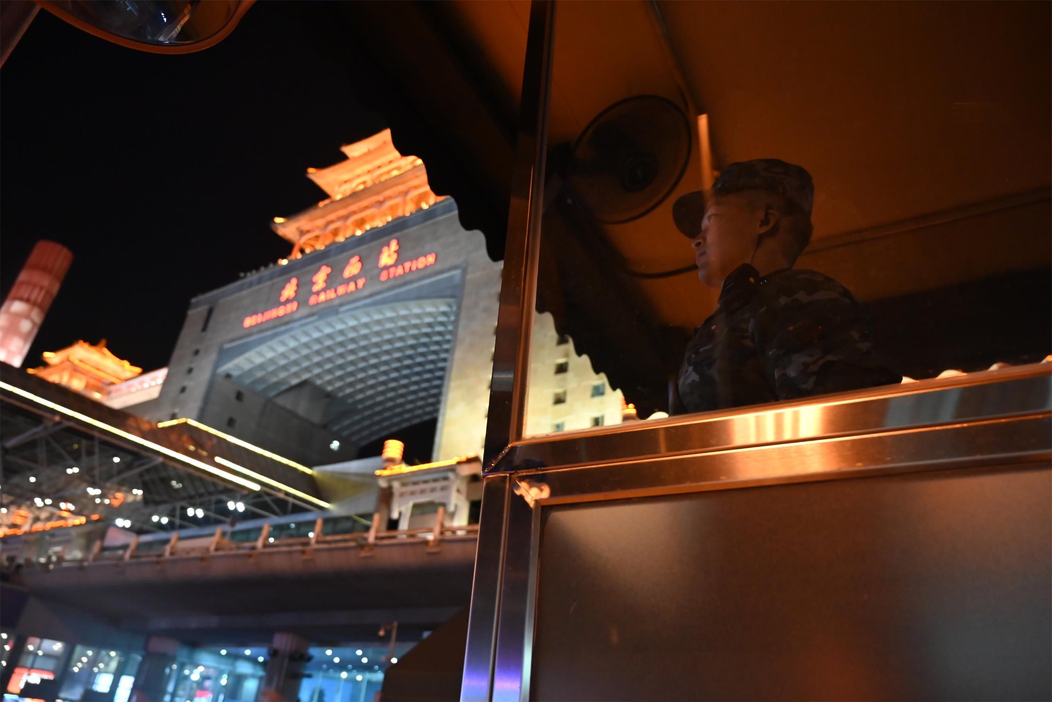 夜晚执勤哨兵精神振作警惕观察着旅客出行情况 张鹏 摄