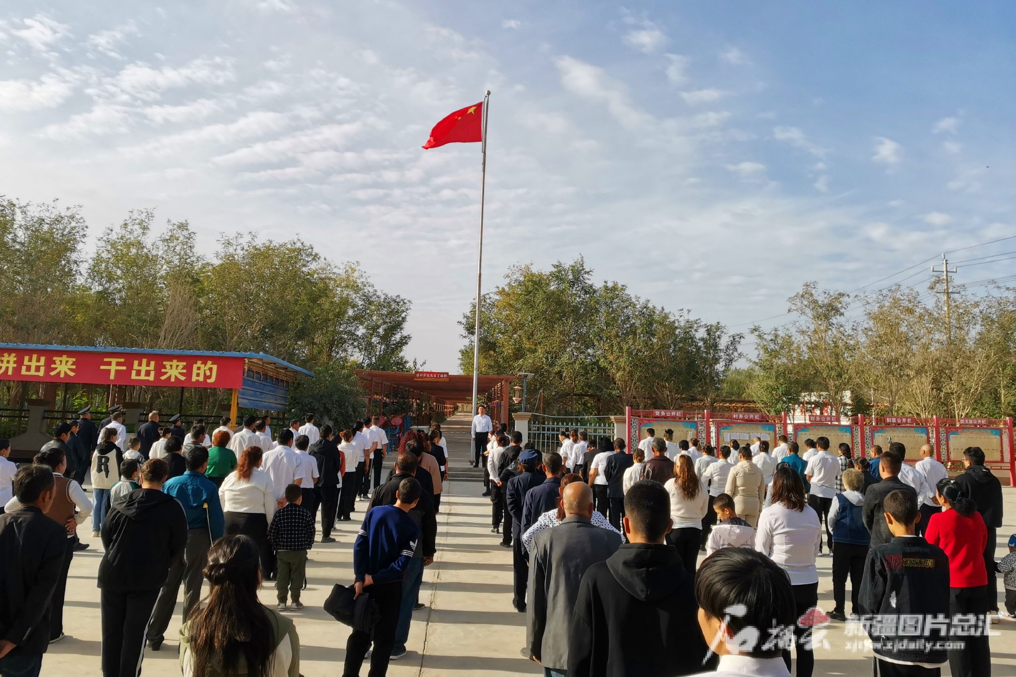 10月1日,若羌县瓦石峡镇塔什萨依村村委会,党员和群众参加升国旗仪式.