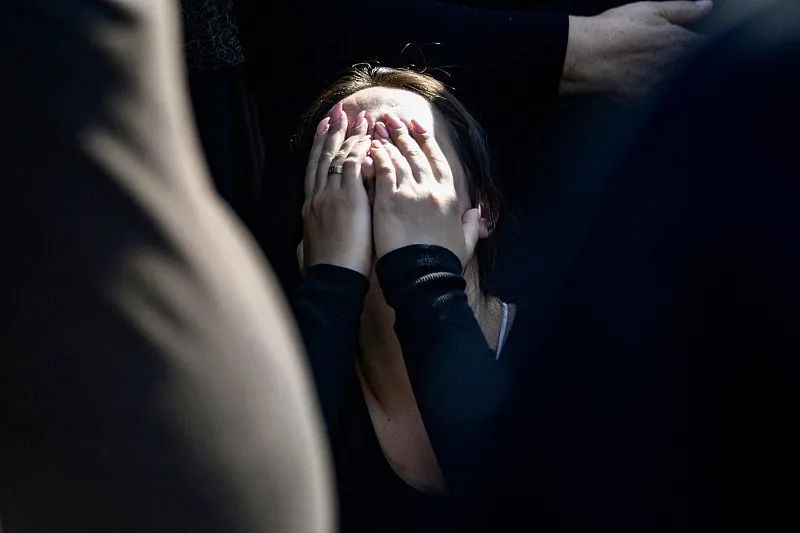 婚礼火灾遇难者葬礼上,一名女性难掩悲伤。