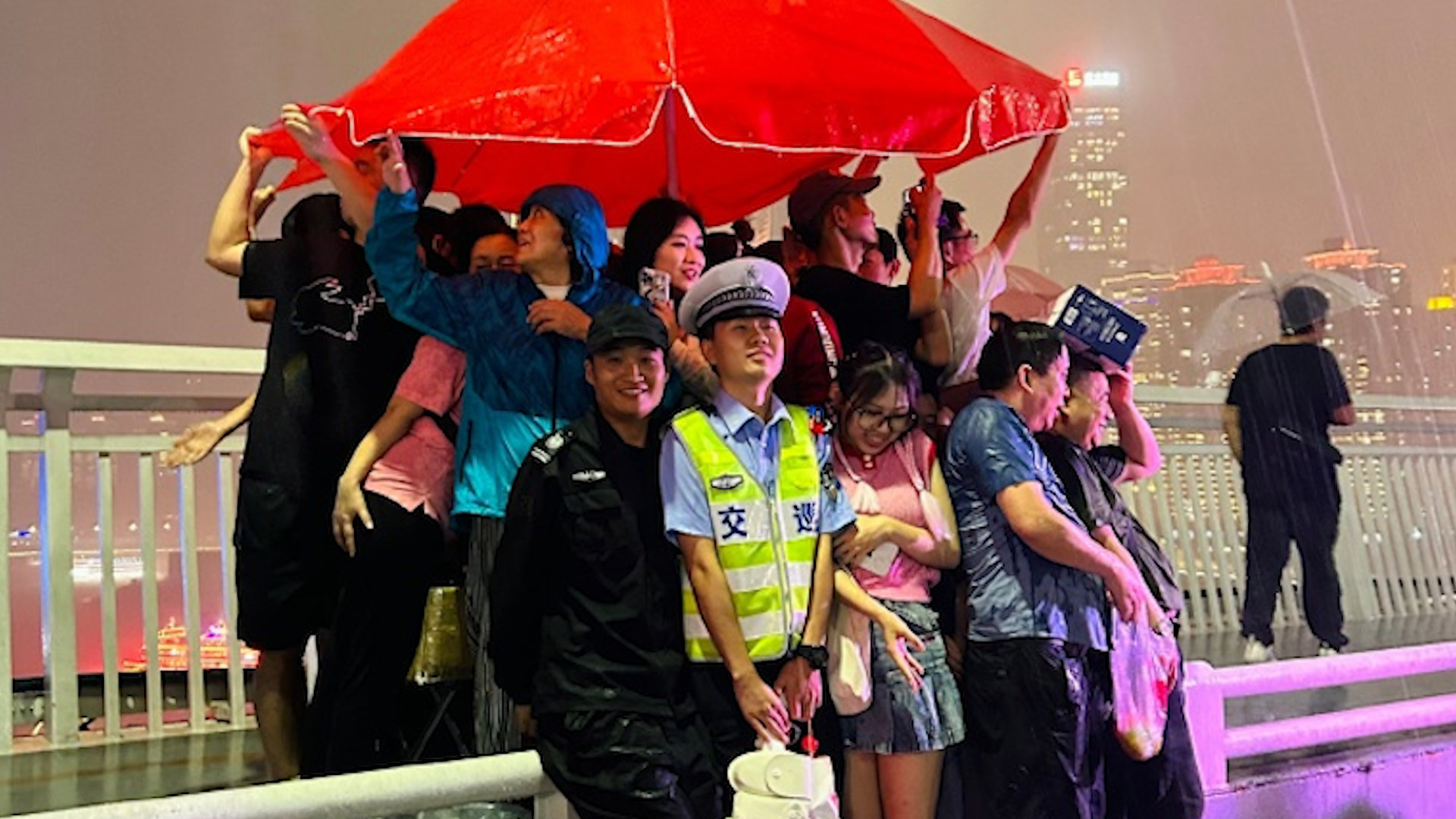 网友雨天无意拍到温馨一幕,游客交警挤在一把伞下:每个人都在笑|交警_新浪新闻