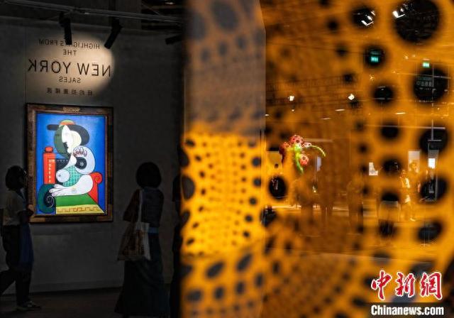 图为为配合香港秋拍而数字品展示的今年11月将在美国纽约苏富比拍卖的毕加索《戴手表的女人》(左)。 中新网记者 侯宇 摄