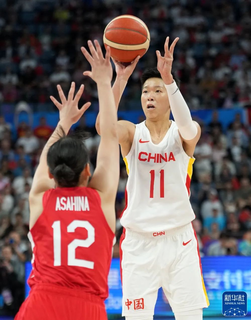 中国队球员黄思静(右)在比赛中投三分球.