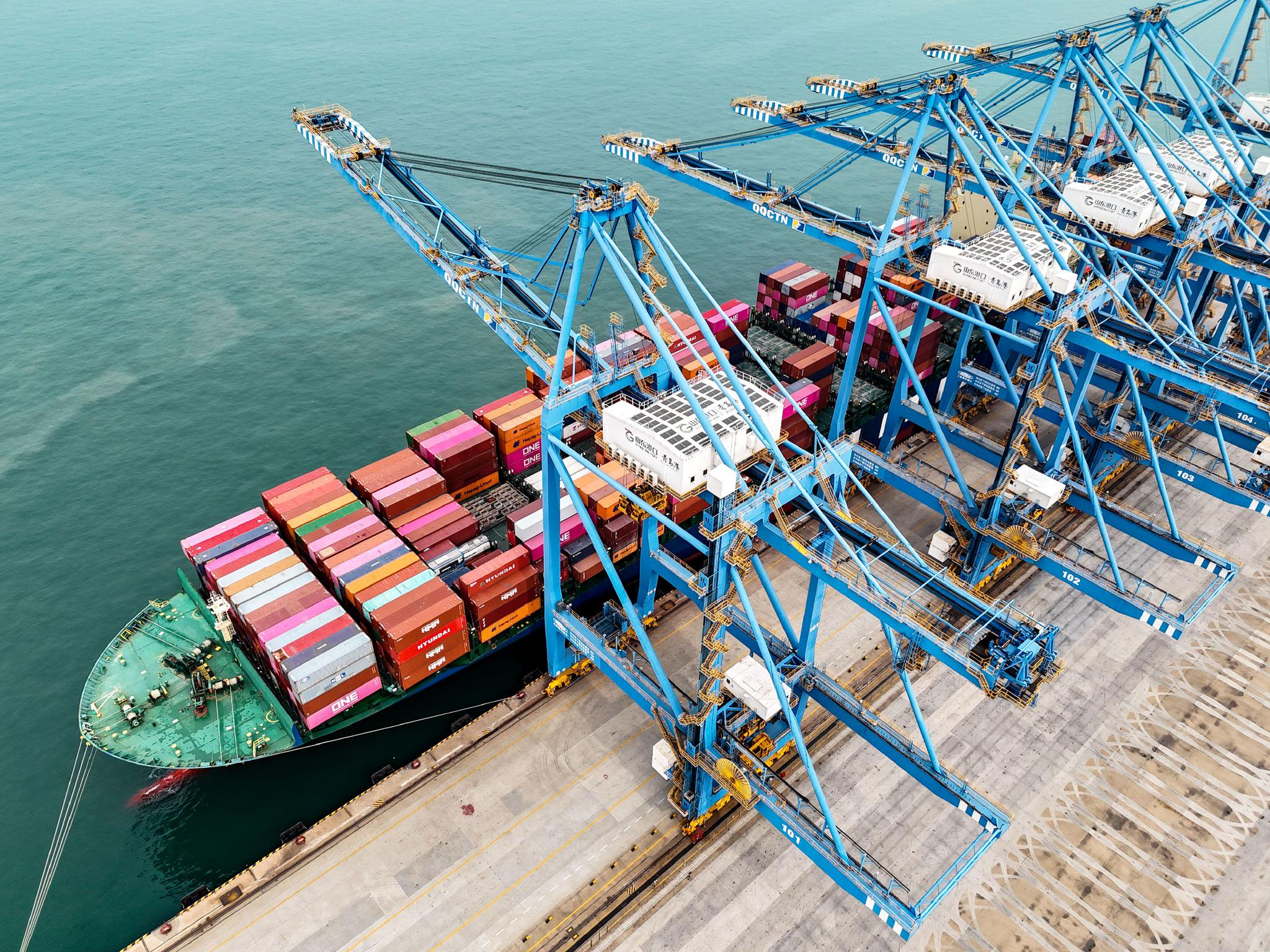 10月7日,数艘货轮靠泊在山东港口青岛港全自动化码头装卸货物