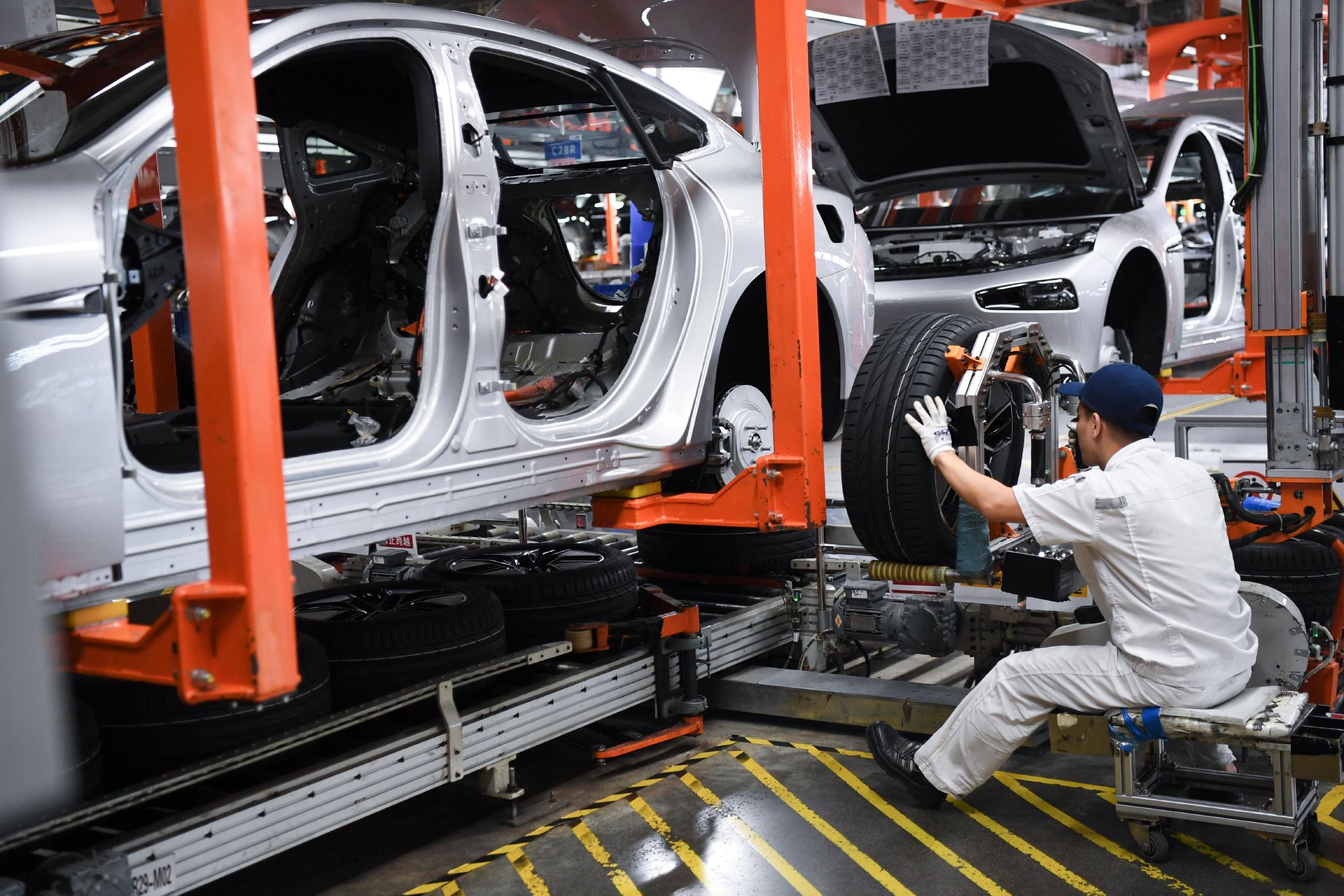 摄10月9日,工作人员在广东肇庆小鹏汽车智能网联科技产业园内总装车间