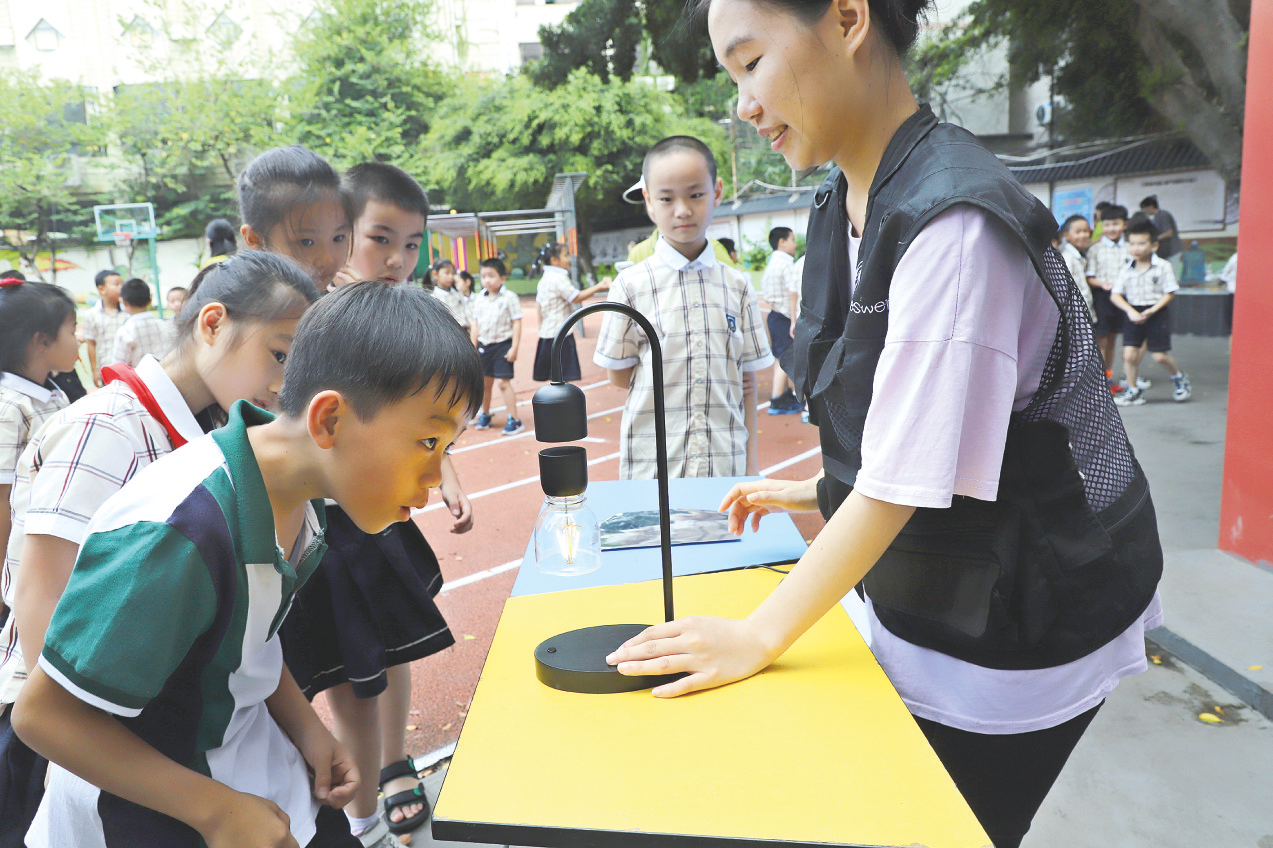     南宁市逸夫小学学生被科普项目吸引。   （岑垚 摄）