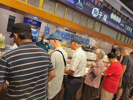 老人在上海市徐汇区天平街道66梧桐邻里汇社区食堂内排队点餐.