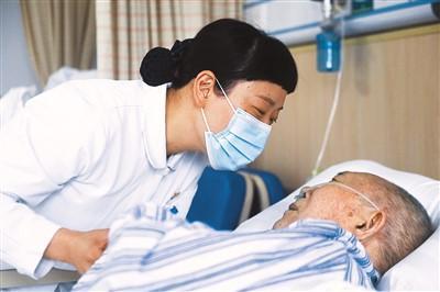 浙江医院医疗照护病房护士长项巧珍在病房内与卧床的患者进行交流.