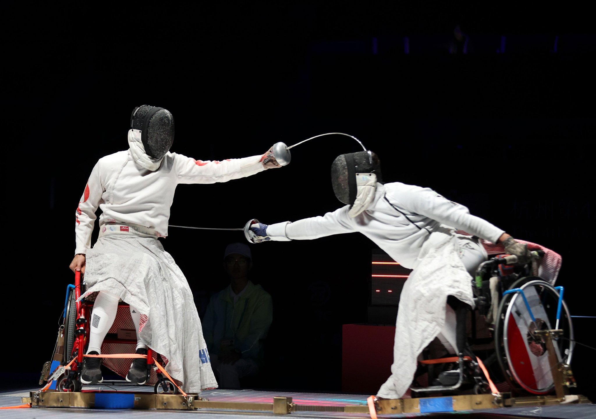10月27日,中国选手孙刚(左)在亚残运会轮椅击剑项目男子重剑个人a级