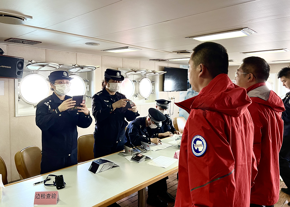 上海移民管理警察为科考队员办理边检查验手续. 黄波 摄