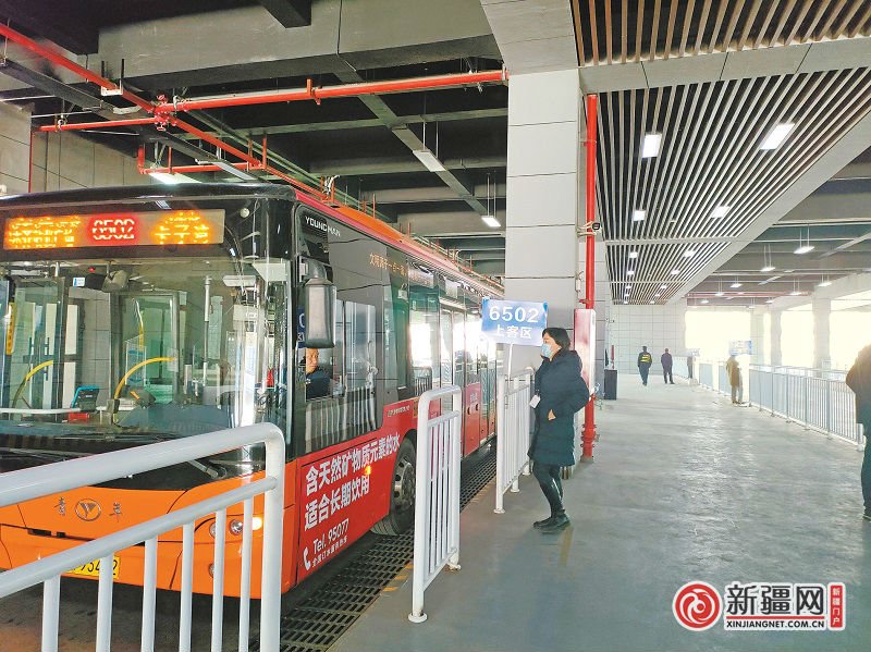 11月3日,在乌鲁木齐站南广场公交车乘车点,乘客正在上车.