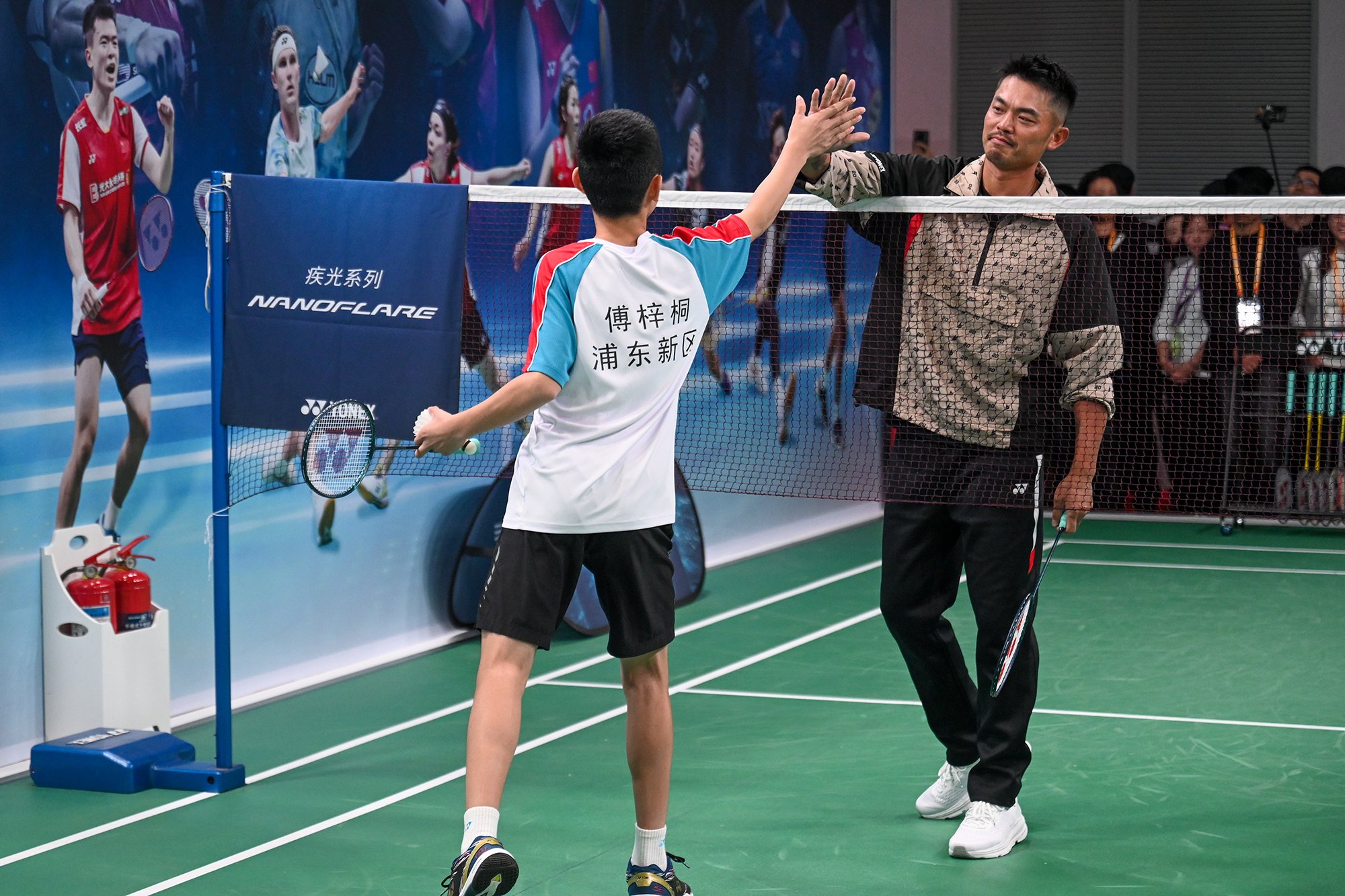 赛后林丹和青少年选手击掌.