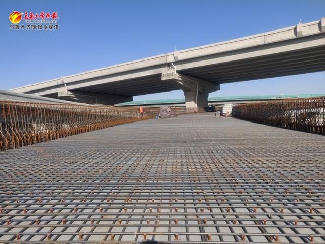 在乌鲁木齐东进场高架道路工程施工现场,正在进行钢箱梁桥面铺装施工