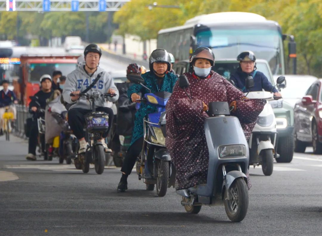 今晨,上海四平路 ,骑车的上班族添加了厚厚的外套,抵御寒风.杨建正 摄