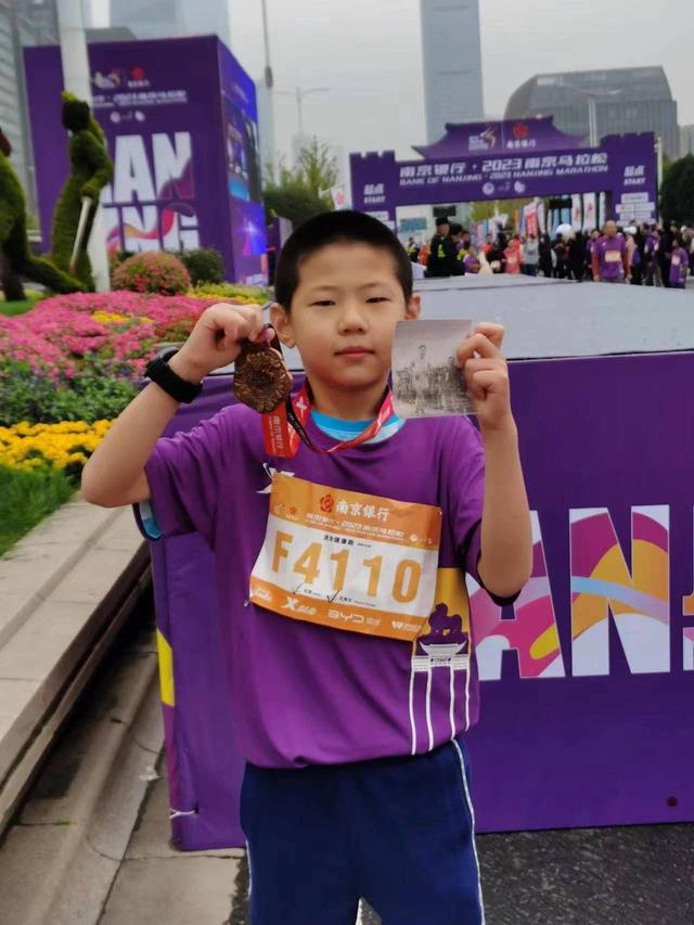 他在冲过终点线之后,拿出了一张新中国首位马拉松冠军夏启宇当年夺冠