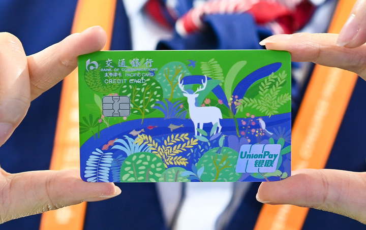 图为2023年4月10日交通银行工作人员展示交通银行绿色低碳主题信用卡.