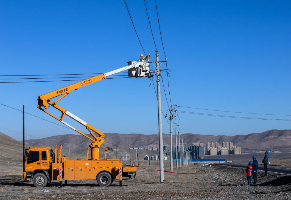 国网乌鲁木齐供电公司工作人员在农网改造现场对10千伏线路进行接火送