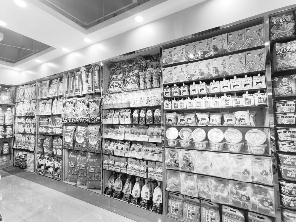 图为省会一家品牌零食店货架上摆放着琳琅满目的特色零食商品.