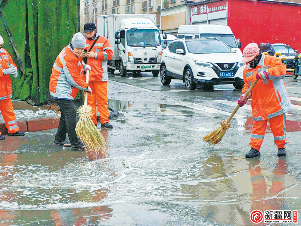 在平川路口,环卫工人清扫积水,方便市民出行.(全媒体记者贾梦妍摄)