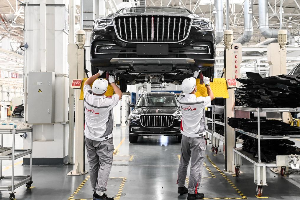 工人在位于吉林长春的一汽红旗工厂总装车间内装配车辆.