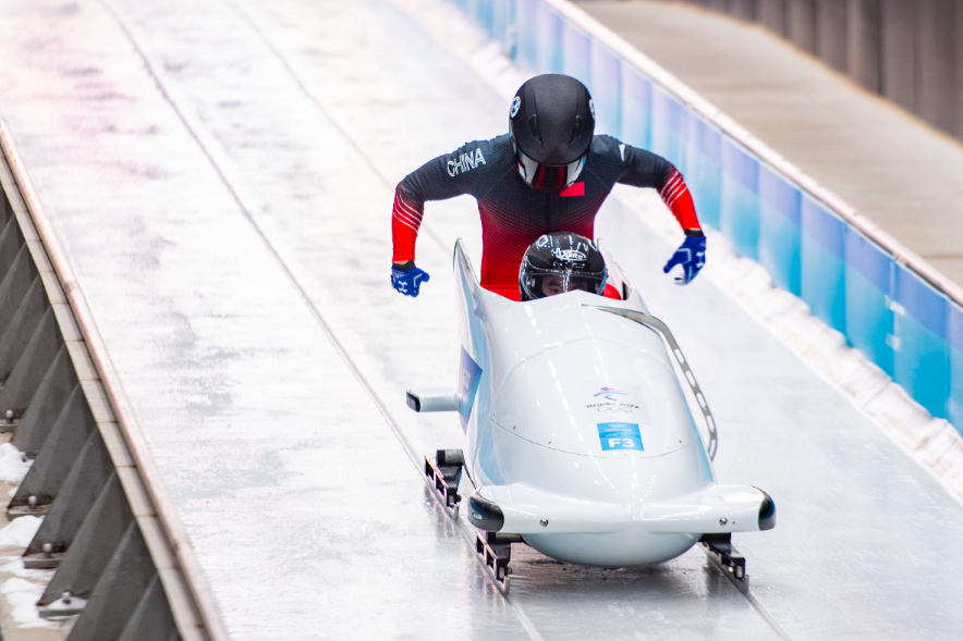 "十四冬"雪车项目比赛中,运动员们奋力滑行.李晓鹏 摄