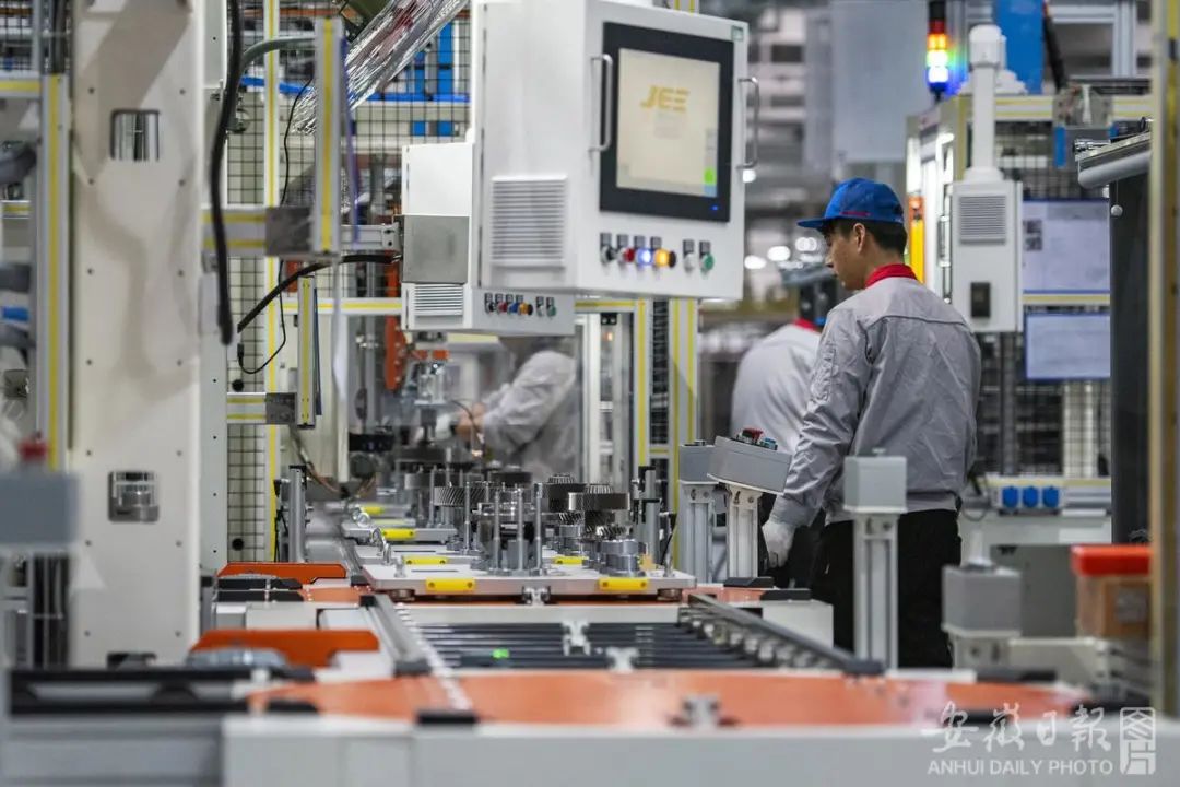 芜湖市繁昌经济开发区的一公司内,技术工人和工业机器人在奇瑞c-dm