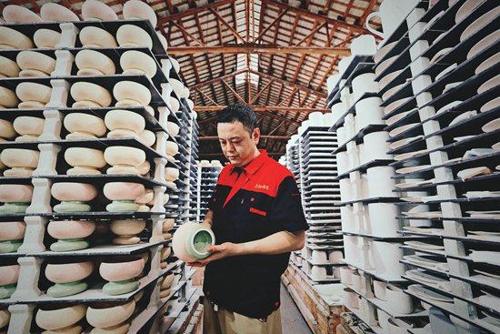 图为陶瓷工厂80后厂长在检查产品情况.张建/摄