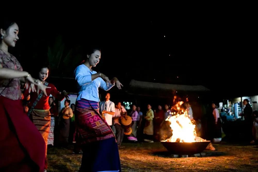 ▲景迈山翁基古寨中，人们围着篝火跳舞庆祝申遗成功。（新华社记者 唐如峰 摄）