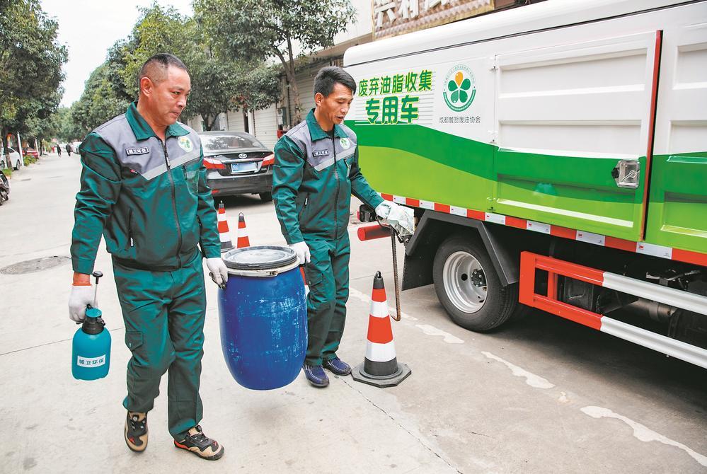 废油收运员准备将油桶搬运上废弃油脂收集专用车