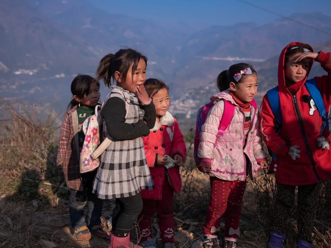 凉山州金阳县马依足乡,彝族小姑娘等公交车去往学校上课.杨凯生 摄