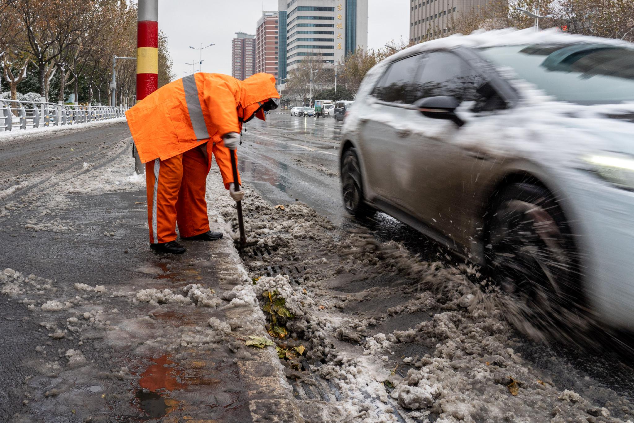 12月11日,山东省济南市环卫工人清扫道路积雪.新华社记者朱峥 摄