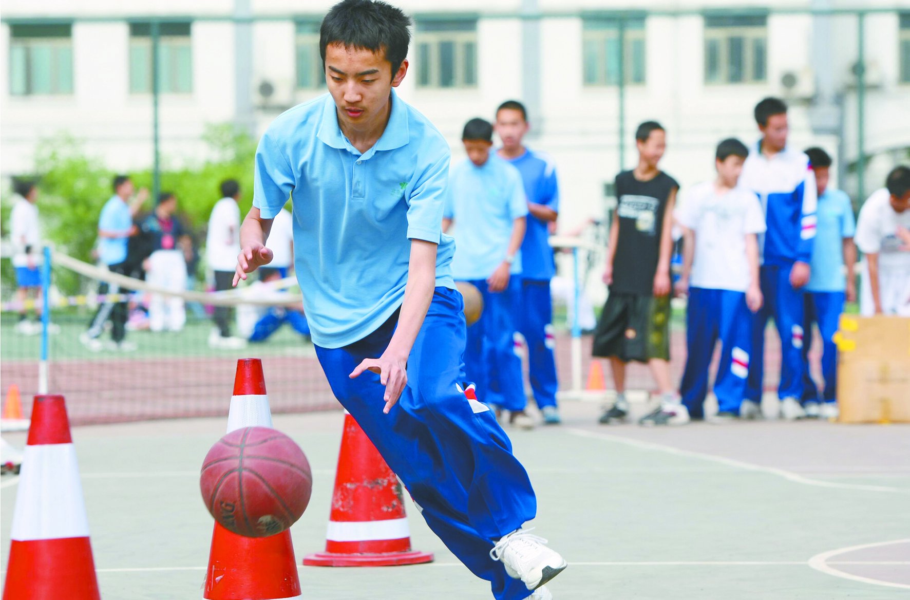 2009年,一初三学生正在中考体育现场进行篮球绕标志物15米往返运球