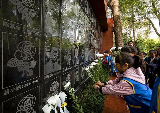 11月,在红岩魂烈士墓前,小朋友给烈士敬献小白花.