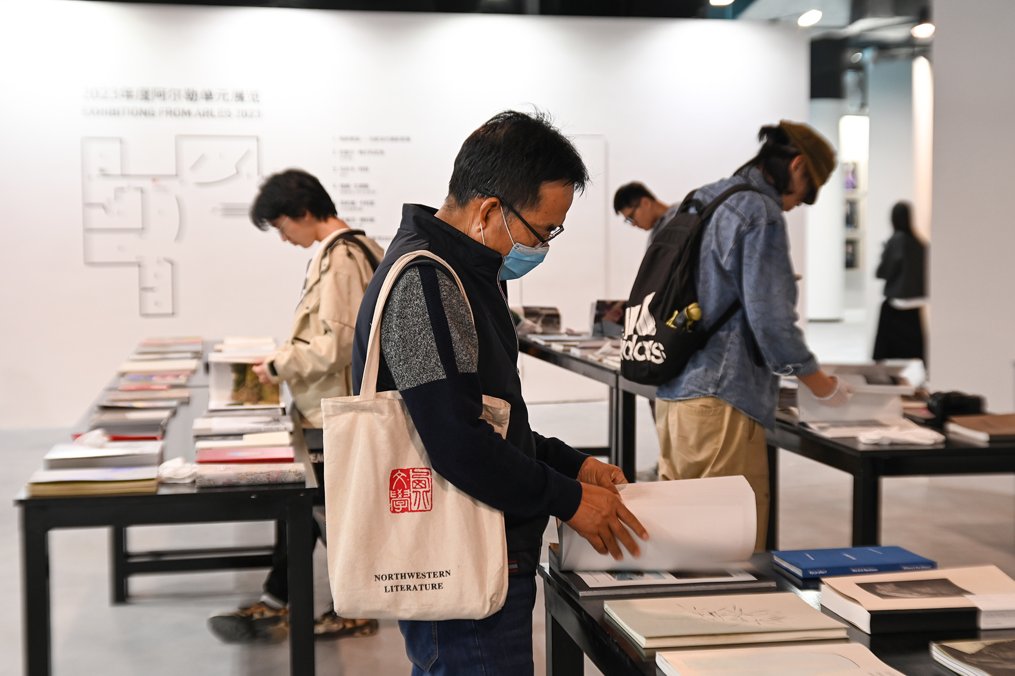 展览现场，观展者在集美·阿尔勒图书展上翻书。