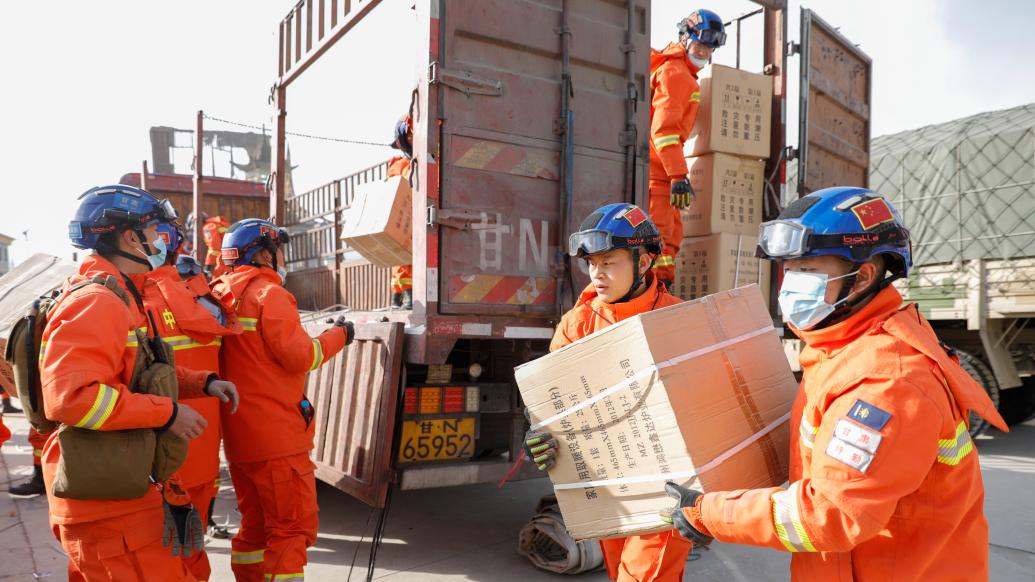 12月19日，在甘肃临夏积石山县大河家镇大河村安置点，消防人员在搬运救援物资。 新华社记者 方欣 摄