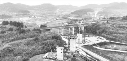 南充市嘉陵区大通镇跨达成铁路特大桥，一列动车飞驰经过建设工地。