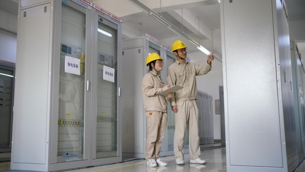 ▲工作人员正在对新装的新型电力系统保护装置进行例行巡视