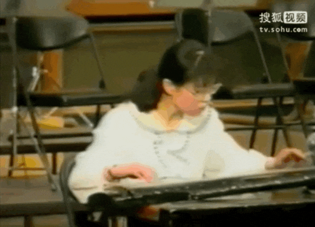 朱令年轻时候在弹古筝。（图/搜狐视频）