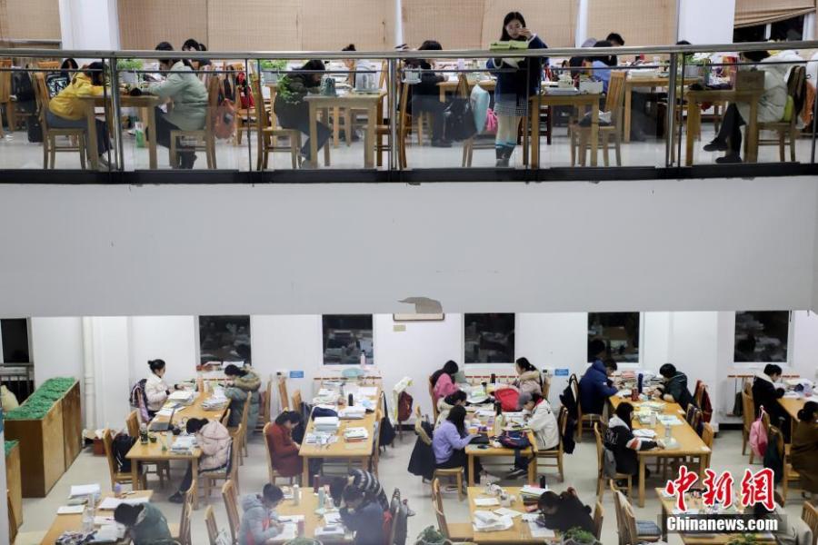 资料图：考研学生在贵州民族大学逸夫图书馆看书复习。中新社记者 瞿宏伦 摄