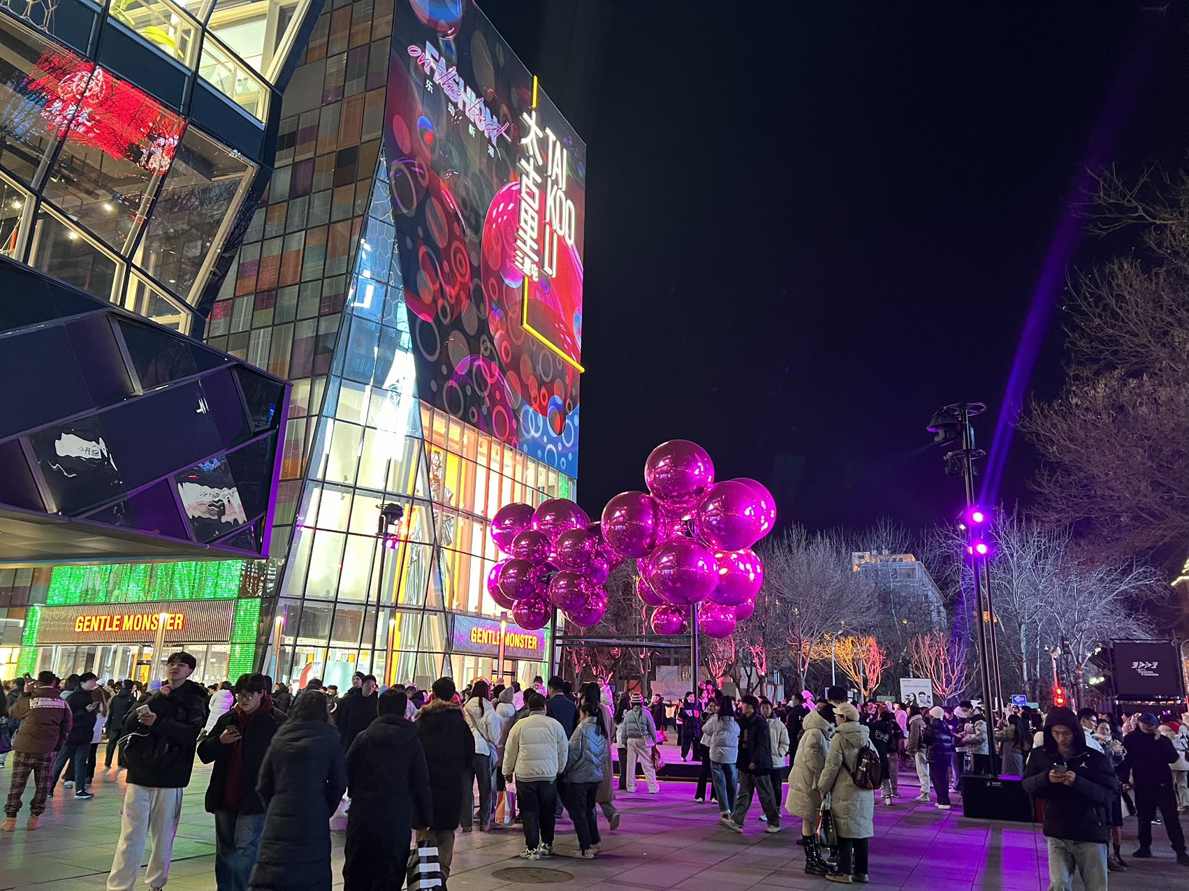 晚上9点,三里屯商圈里的时尚装置前挤满了前来打卡的游客,一串串巨大