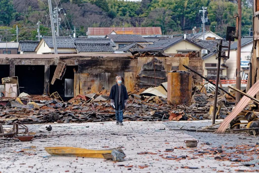 1月4日，一名市民查看日本石川县轮岛市“轮岛早市”废墟。新华社记者 张笑宇 摄